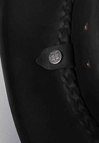 Black leather hat featuring braided detailing and a silver button accent. Smooth texture with a slightly shiny finish and structured shape.