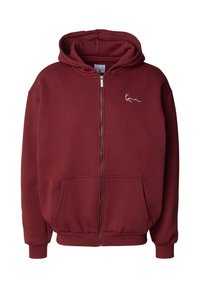 Bordo krāsa zip-up džemperis izgatavots no flīsa. Iespējas: kapucīne ar auklu, priekšējās kabatas, ribota aproce un neliela baltā logo uz krūšu daļas.