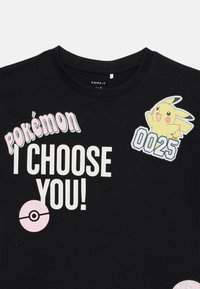 Black cotton T-shirt featuring colorful "Pokémon" text, cartoon Pikachu graphic, and a Pokéball symbol. Fits youth sizes 7-8.