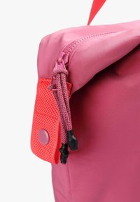 Bolso rosa con un diseño de solapa, que cuenta con una cremallera y un cordón ajustable. Incluye un acento de tela naranja texturizada.