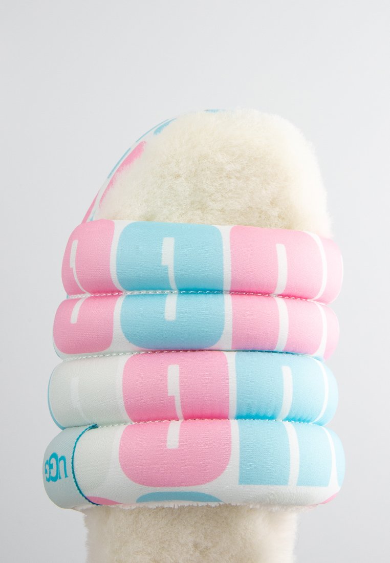 Infradito fuzzy pink e blu con interno in peluche, forma arrotondata e design del logo bianco prominente sulla fascia superiore, progettati per il comfort.