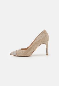 Décolleté beige con punta affusolata, coperta da piccoli strass luccicanti, e dotata di un elegante tacco a stiletto.