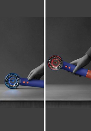 Utensile elettrico con impugnatura blu, testa circolare e due pulsanti. Il lato sinistro mostra una luce blu, il lato destro mostra una luce rossa e decorazioni a rete.