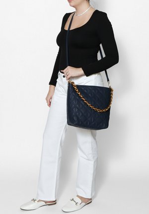 Borsa a spalla in pelle trapuntata blu navy con tracolla in catena dorata intrecciata, forma rettangolare, superficie testurizzata e chiusura con zip.