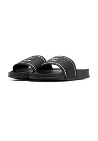 Svarta slidesandaler med ett brett, böjt rem med vita accentlinjer och en logotyp. Textuerad fotbädd och platt sula för komfort.