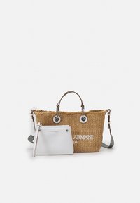 Sac fourre-tout en paille tissée avec des accents en cuir marron et des accessoires en argent, comprenant une pochette zippée blanche avec logo. Sangle ajustable incluse.