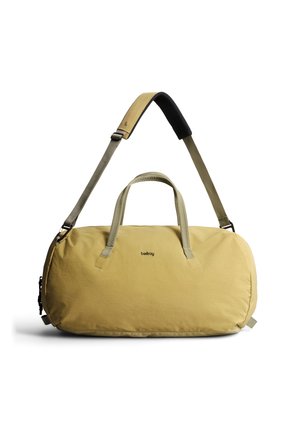 Borsa duffle rettangolare color senape con doppi manici, tracolla imbottita regolabile e piccolo logo nero "bellroy" centrato sul davanti.