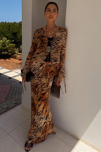 Long dress and cardigan set in a tiger print pattern, featuring shades of orange and black. Light, flowing fabric with loose sleeves.