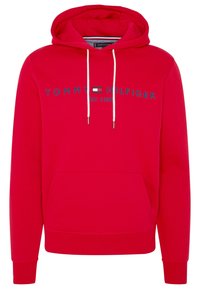 Felpa rossa con cappuccio e lacci bianchi, tasca frontale e scritta e logo "Tommy Hilfiger" blu navy con "Est. 1985" sul petto.