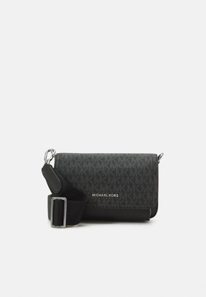 Sac bandoulière Michael Kors gris foncé avec une large sangle noire réglable et des détails en métal argenté, motif monogramme sur le corps principal.