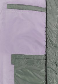 Lichtpaarse jas met groene accenten, met meerdere met rits afgesloten zakken en een gladde, glanzende textuur.