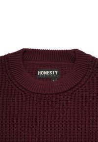 Burgundy knitted sweater featuring a ribbed texture, wide crew neckline, and branded black label reading "HONESTY RULES."