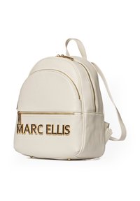 Sac à dos en cuir crème avec un dessus arrondi, deux compartiments zippés et quincaillerie dorée arborant le logo "MARC ELLIS" à l'avant.