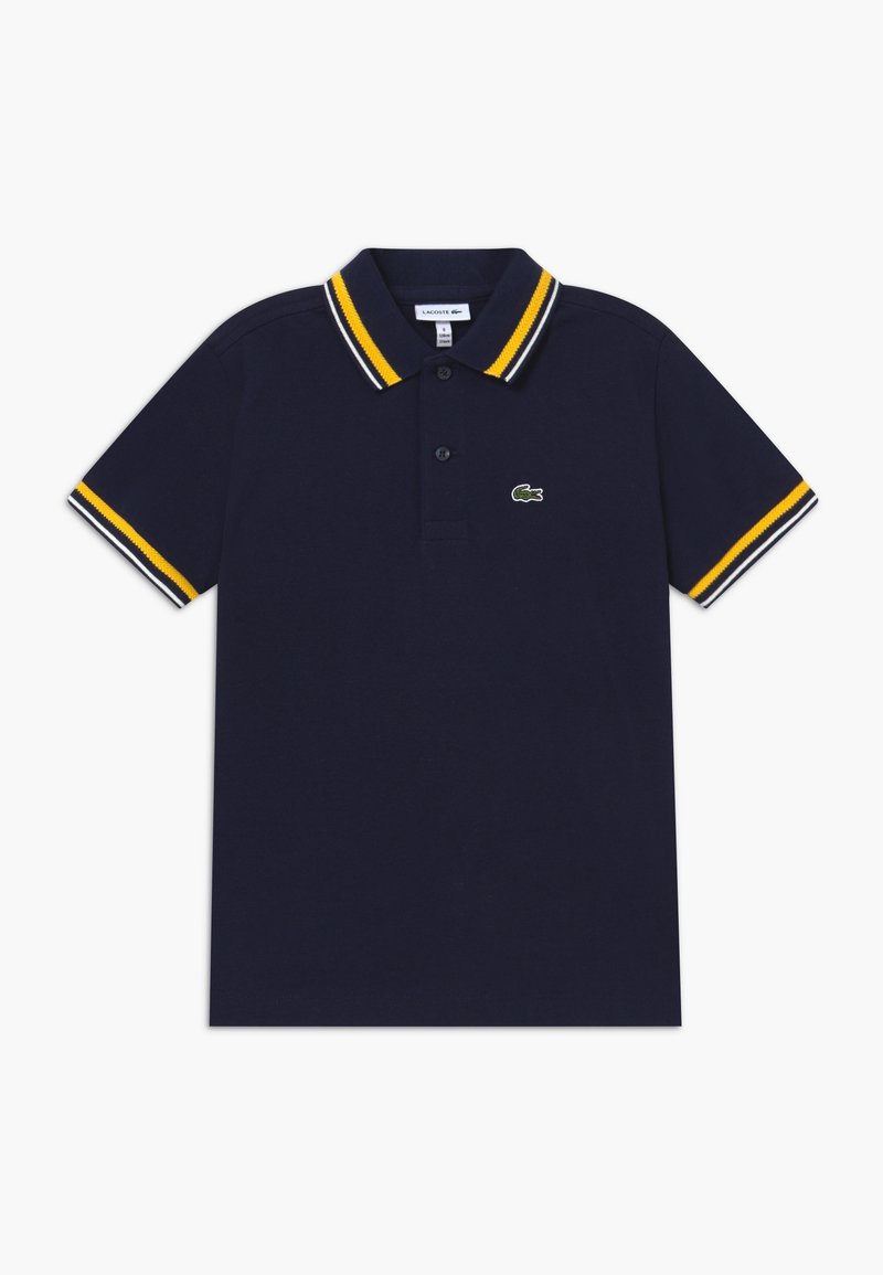 Polo bleu marine à manches courtes avec col et bordures de manches rayés jaune, blanc et noir, avec un petit logo crocodile vert sur la poitrine.