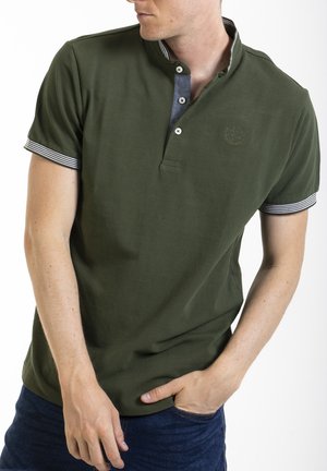 Polo en vert olive avec un col court à boutons, une patte de boutonnage grise et des poignets rayés. Présente un logo brodé sur la poitrine.