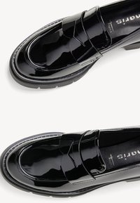 Paire de mocassins en cuir verni noir brillant avec semelles épaisses en caoutchouc, bouts arrondis et détail de bride sur le dessus.