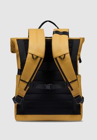 Zaino giallo e nero con spallacci imbottiti, corpo testurizzato, fibbie regolabili e una maniglia superiore per il trasporto.