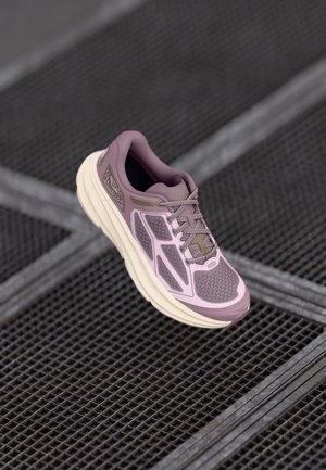 Pantofii sport de culoare violet deschis, cu partea superioară din plasă, suprapuneri texturate contrastante și talpă bine îmblănită. Dispun de șireturi și detalii minime de branding.