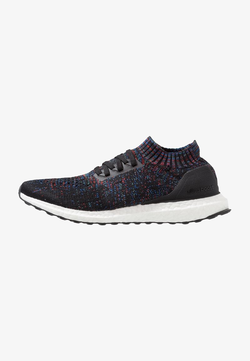 Chaussure de sport en maille noire avec des taches multicolores. Comprend un col montant, un design à lacets et une semelle blanche Boost pour l'amorti.