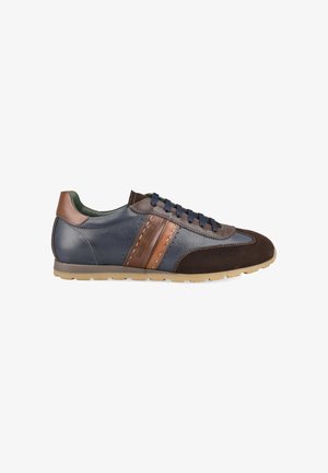 Baskets basses pour homme en cuir bleu marine, bout et talon en daim marron, bandes en cuir cognac et lacets foncés sur semelle en caoutchouc beige.