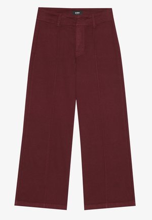 Burgunderfarbene weite Hosen mit strukturiertem Design, ausgestattet mit einem Reißverschluss auf der Vorderseite, zwei vertikalen Nähten und einem umgeschlagenen Bund. Glatte Baumwolltextur.