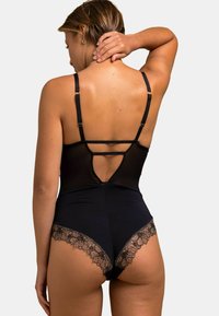 Body noir avec dentelle, bretelles réglables et détail ouvert dans le dos. Tissu doux avec des accents de dentelle florale au niveau des jambes.