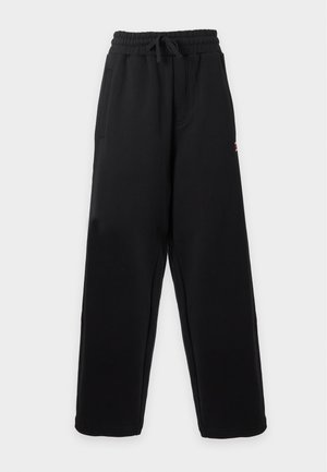 Pantalones deportivos negros de corte ancho con cintura elástica y cordón, bolsillos laterales y un pequeño logo rojo y blanco en el muslo izquierdo.