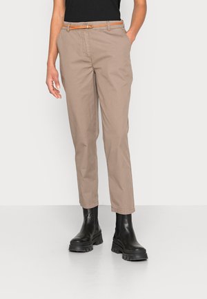 Chinos marron clair au design ajusté, dotés d'une ceinture tissée orange, associés à des bottines noires chunky. Tissu en coton lisse.
