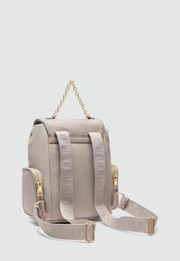 Sac à dos gris clair avec une poignée en chaîne, des bretelles réglables, des poches zippées, des accessoires en métal doré et des détails en tissu texturé.