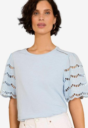 T-shirt azzurro chiaro a maniche corte con maniche a sbuffo decorate da pizzo e dettagli di cucitura sottili sul colletto. Tessuto morbido al tatto.