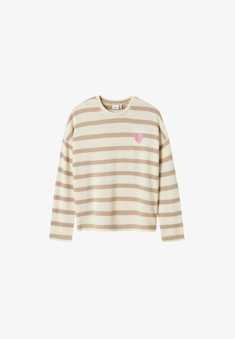 Pull-over rayé beige et crème avec des manches longues, un col rond, et une broche en forme de cœur rose sur la poitrine. Fini en texture douce.