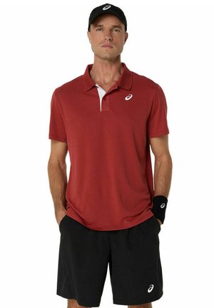 Polo rouge avec détail de col blanc, associé à des shorts noirs. Une casquette noire et un bracelet assorti présentent le logo Asics.