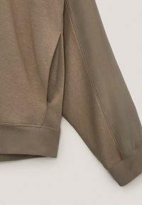 Olive green sweatshirt featuring a soft texture, ribbed cuffs and hem, and a design with a slightly tapered shape and side panel detail.