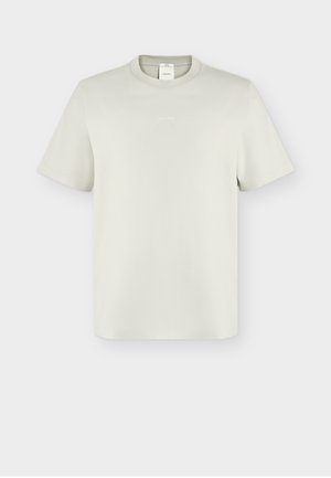 Camiseta de manga corta de cuello redondo en color blanco roto con pequeño logo centrado de Calvin Klein en el pecho y etiqueta visible en el interior del cuello.