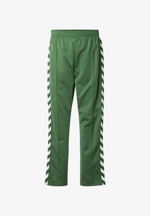 Pantalon de survêtement vert en tissu doux, avec des bandes blanches en forme de chevrons le long des côtés, une taille élastique et une coupe fuselée.