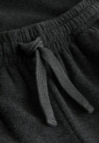 Sorte fleece joggers med elastisk talje, tekstureret stof og en vævet snor til justerbar pasform.