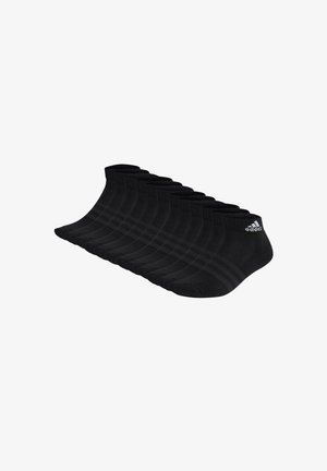 Mustat nilkkasukat järjestettynä riviin, pehmeästä materiaalista valmistetut, joissa on ribbireunus ja kolme vaakaraitaa sivussa.