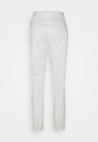 Pantalons blancs en tissu léger. Design ajusté avec une texture lisse, une taille structurée et des chevilles fuselées.