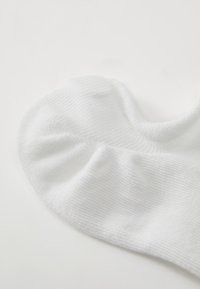 Λευκή κάλτσα μέχρι τον αστράγαλο φτιαγμένη από υφασμάτινη υφή με ραβδωτό σχέδιο, διαθέτει ένα λείο μανίκι και χωρίς ραφές στο σημείο των δακτύλων για άνεση.