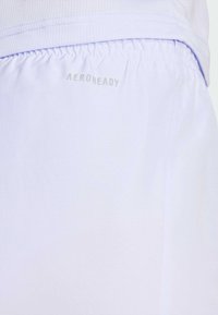 Pantalones cortos deportivos de color púrpura claro, hechos de una tela suave y transpirable con una cinturilla elástica. Presentan el logo "AEROREADY" en plata en el lateral.