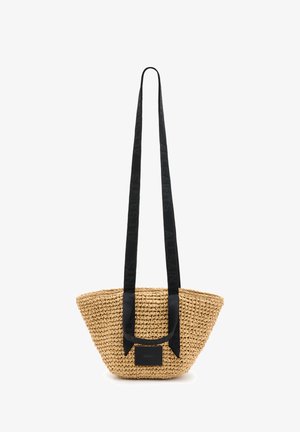 Geflochtene Strohtasche mit einem breiten, schwarzen Stoffgurt, der eine geprägte Markenkennzeichnung aufweist. Sie hat eine konische Form und einen flachen Boden.