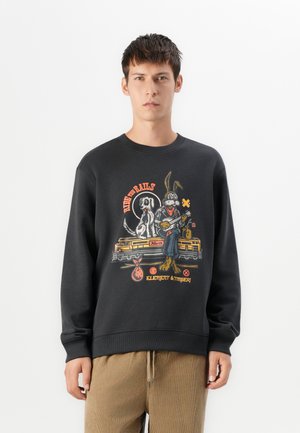 Black sweatshirt featuring a colorful graphic of a rabbit and dog with a train background. Ribbed cuffs and hem, casual fit.