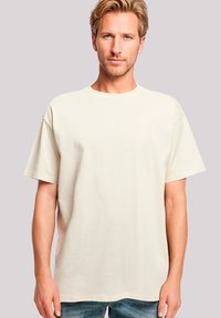 Beige short-sleeve T-shirt made of soft fabric. Relaxed fit with a round neckline and straight hem, showcasing a smooth texture.