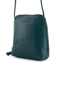 Kompakt mørkegrøn skuldertaske i læder med en enkelt lynlås på højre side og præget "VENEZIA"-logo på forsiden.