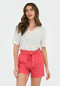 Witte V-hals T-shirt van een katoenmix en koraalkleurige geweven shorts met een gestrikt middel. Gladde textuur met een ontspannen pasvorm.