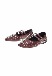 Scarpe flat bordeaux con due cinturini a fibbia, decorate con borchie e spuntoni in argento che ricoprono la superficie.