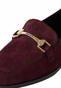 Bordeaux suède instapper met een gouden metalen gesp-accent en zwarte zool. Beschikt over een gladde textuur en gedetailleerde stitching nabij de bovenkant.
