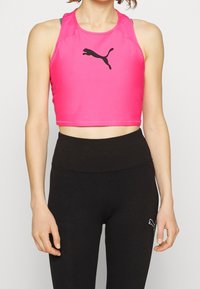 Rosa kort sportstopp i stretchmaterial, med en svart Puma-logotyp i mitten. Matchas med svarta högmidjade leggings.