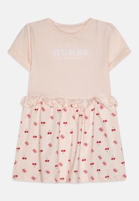 Jasnoróżowa sukienka z krótkimi rękawami, z falbaniastej spódnicy, w deseń wiśniowy i haftowanym logo "GUESS LOS ANGELES" na dekolcie.