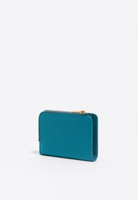 Cartera de cuero en color verde azulado con forma rectangular, cierre de cremallera y herrajes dorados. Textura suave con un diseño minimalista y sin patrones visibles.